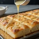 Drizzling glaze on sweet cinnamon focaccia